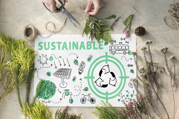 Une feuille de papier avec écrit 'sustainable' (durable) et plusieurs dessins référant à l'écologie, au recyclage et aux énergies renouvelables.